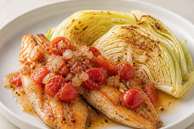 Peixe grelhado com repolho e tomates na frigideira