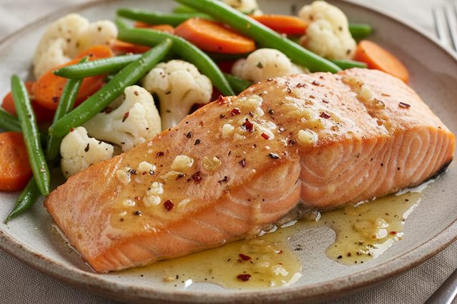 Salmão assado com manteiga de alho e legumes