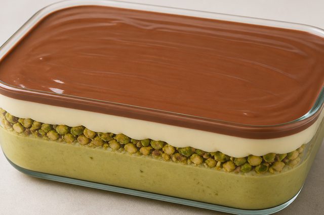 Sobremesa de pistache na travessa com ganache branca e casquinha
